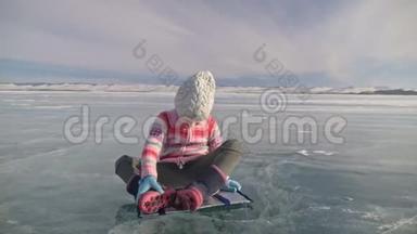 女孩在冬天练习瑜伽。孩子们在自然界的冰上做伸展和冥想。儿童练习瑜伽